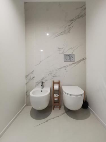 a white bathroom with a toilet and a sink at Le Dimore Degli Archi Catania in Catania