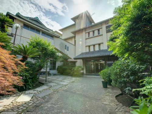 an external view of a building with trees and bushes at Iwamotoro in Fujisawa