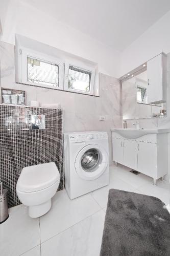 a bathroom with a washing machine and a sink at HACIENDA MIA with pool,BBQ,free parking in Zadar