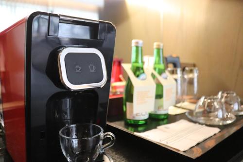 a coffee maker on a table with bottles of wine at Pullman Ciawi Vimala Hills Resort in Bogor
