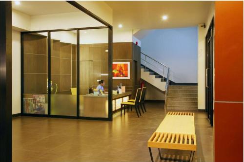 a lobby with a staircase and a woman sitting at a counter at Baan Saikao Plaza Hotel & Service Apartment in Ko Chang