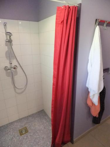 une cabine de douche avec rideau de douche rouge et rideau de douche rouge dans l'établissement Gîte Les Esparrus, à Villecroze