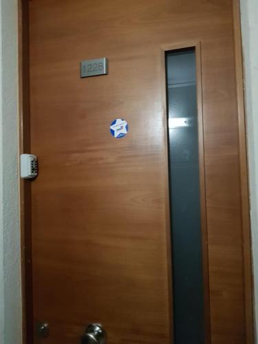 a wooden elevator door with a sign on it at Carmen con Argomedo, PARKING por pagar in Santiago