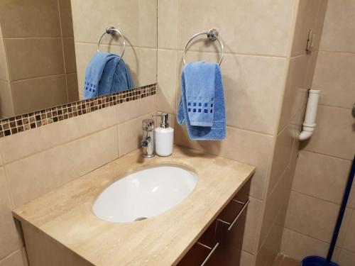ein Badezimmer mit einem Waschbecken und blauen Handtüchern in der Unterkunft Carmen con Argomedo, PARKING por pagar in Santiago