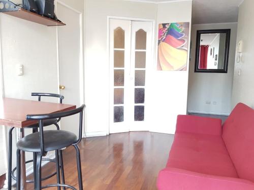 a living room with a pink couch and a table at Departamento Paseo Bulnes Metro La Moneda in Santiago