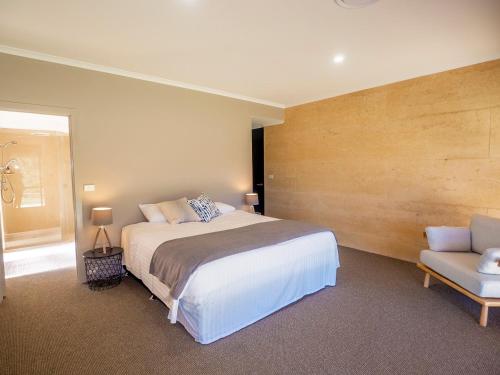a bedroom with a large bed and a chair at Tanah Marah in Margaret River Town
