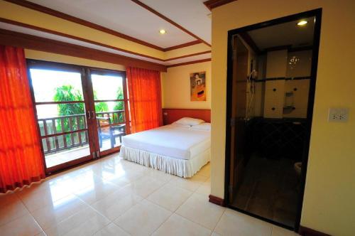 a bedroom with a bed and a bathroom with a balcony at Alina Grande Hotel & Resort in Ko Chang