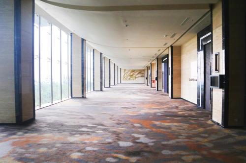 an empty hallway in an office building with windows at InterContinental Bandung Dago Pakar by IHG in Bandung