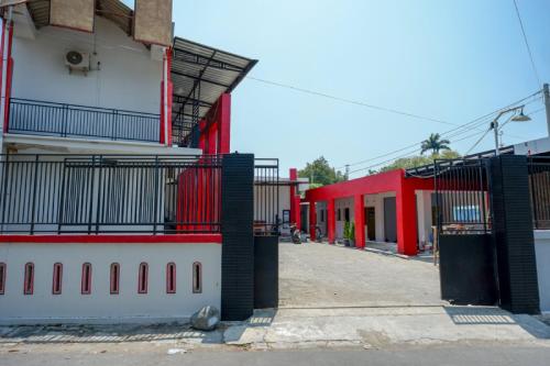 a group of buildings with red and white at RedDoorz Syariah near Alun Alun Tegal in Tegal