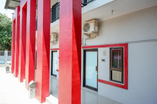 a row of red columns on the side of a building at RedDoorz Syariah near Alun Alun Tegal in Tegal