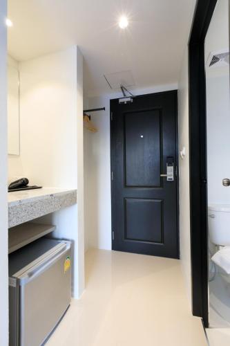 a bathroom with a black door and a toilet at Prima House Pattaya in North Pattaya