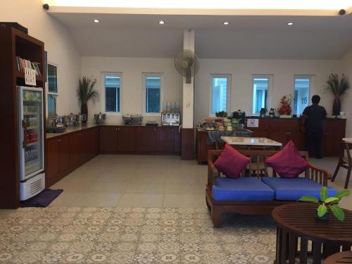uma sala de estar com um sofá azul e uma mesa em Impress Resort em Thalang