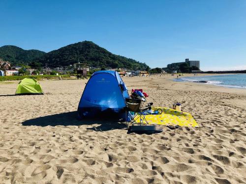 a blue and green tent on a sandy beach at Izu Kansya in Atami