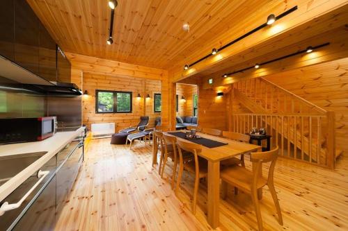 eine Küche und ein Wohnzimmer mit einem Tisch und Stühlen in der Unterkunft Wadano Woods by Hakuba Hotel Group in Hakuba