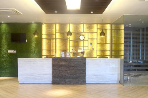 a lobby with a counter with a clock on a wall at Hotel 88 Embong Kenongo - Kayun By WH in Surabaya