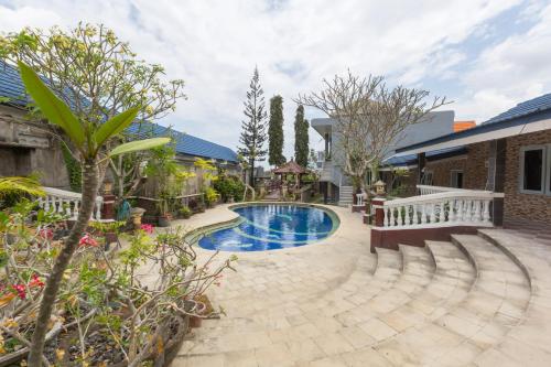 a backyard with a swimming pool and a house at Bali Aman Darling House in Canggu