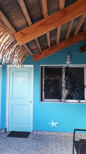 a blue wall with a blue door and windows at Hotel & Apartments "CHEZ HIVA" in Hanga Roa