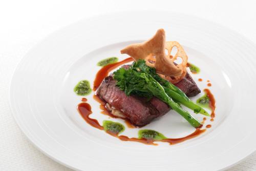 a white plate with a piece of meat and broccoli at LEGOLAND Japan Hotel in Nagoya