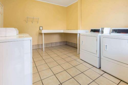 a kitchen with white appliances and a tiled floor at Days Inn by Wyndham Natchez in Natchez