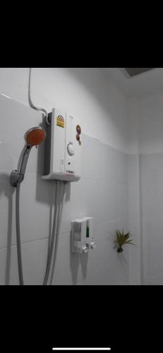a shower in a bathroom with a hose on the wall at D Heart Homestay in Bangkok