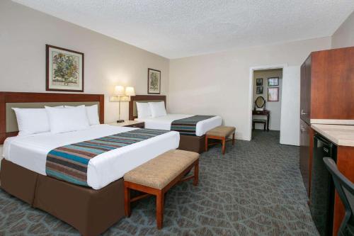 Cette chambre comprend deux lits et une télévision. dans l'établissement Days Inn by Wyndham Natchez, à Natchez