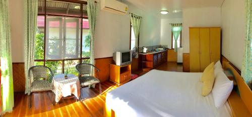a bedroom with a large bed and a television at Mali House in Mae Nam