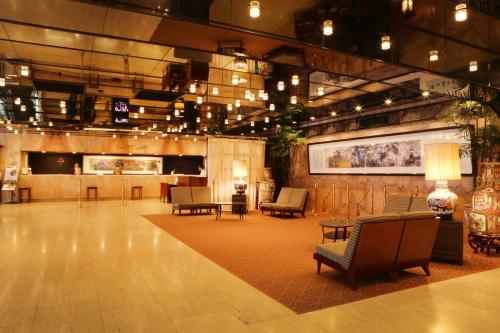 een grote lobby met stoelen en tafels in een gebouw bij Rose Hotel Yokohama, The Distinctive Collection By WORLDHOTELS in Yokohama