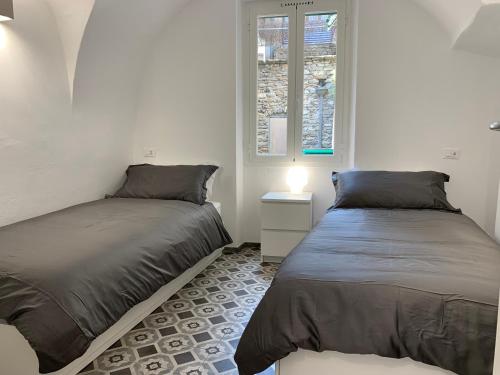 a bedroom with two beds and a window at Al Castello in Dolceacqua