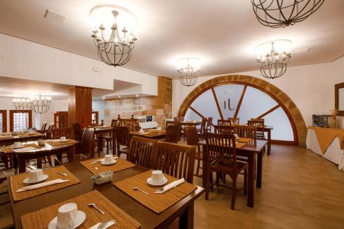 a restaurant with wooden tables and chairs and a large window at Hotel Jaime I in Mora de Rubielos