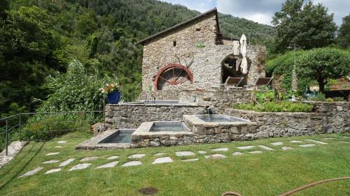 a stone building with two sinks in a yard at Old Mill in Pigna