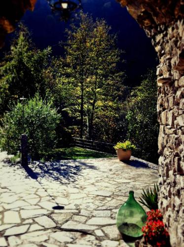 a stone walkway with two green vases on a wall at Old Mill in Pigna