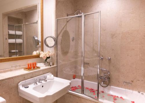 a bathroom with a shower, sink, and tub at The Hotel Windsor in Melbourne