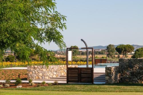 a gate in a park with a stone wall at Podere del Priorato in Albinia