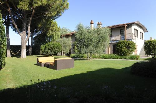 a garden with a bench in front of a house at Podere del Priorato in Albinia