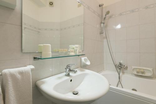 bagno bianco con lavandino e doccia di Hotel Airone a Rimini