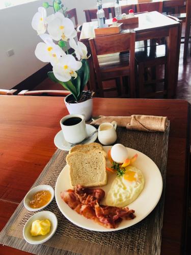 a plate of breakfast food with eggs bacon and toast at Tongatok Cliff Resort in Mambajao