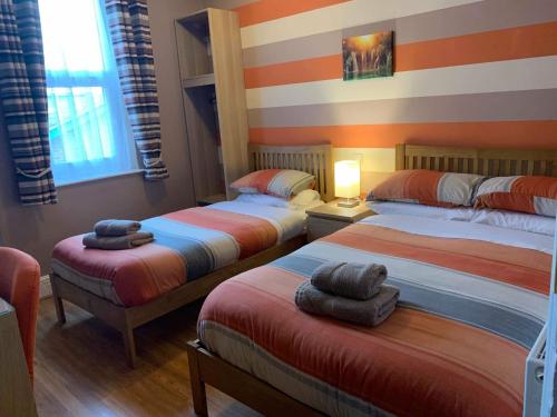 - une chambre avec 3 lits et des serviettes dans l'établissement Central Hotel, à Sutton in Ashfield