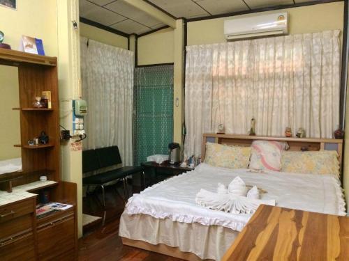 a bedroom with a large bed with white sheets at PEE HOMESTAY LOPBURI in Ban Tha Krayang