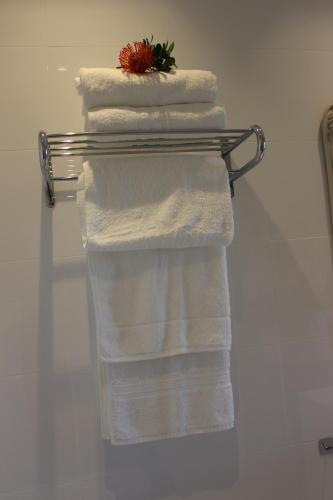 a group of towels on a towel rack in a bathroom at 365 Sunset Self Catering Apartments in Noordhoek