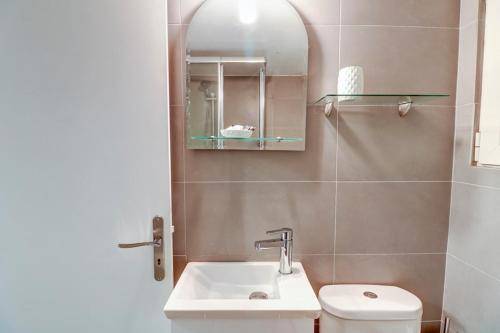 uma casa de banho com um lavatório, um WC e um espelho. em Victoria Jewels em Atenas