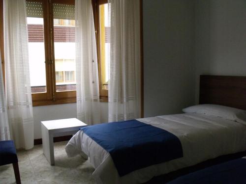 a bedroom with a bed and a window at Pensión Arroniz in Arróniz