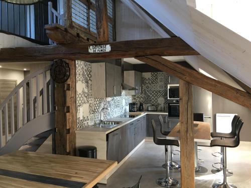 Il comprend une cuisine avec des plafonds en bois, une table et des chaises. dans l'établissement Appartement style industriel avec terrasse, à Givet