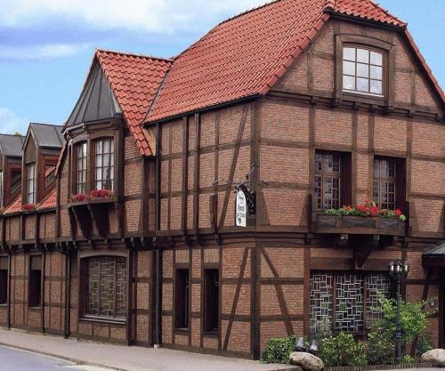 an old building with a red roof at Hotel Restaurant zur Linde in Pattensen