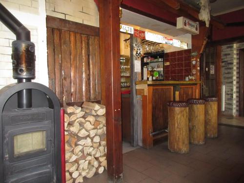 een kamer met een fornuis en een bar met houtblokken bij Penzion Shamrock in Třebíč