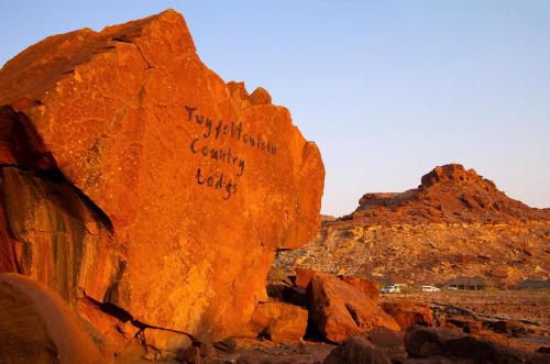 a rock with writing on it in the desert at Twyfelfontein Country Lodge in Twyfelfontein