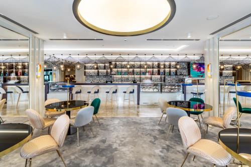 a restaurant with tables and chairs and a bar at Mercure Dubai Barsha Heights Hotel Suites And Apartments in Dubai