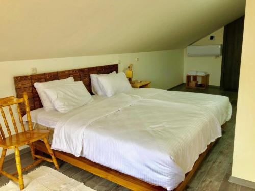 a bedroom with a large white bed with a wooden headboard at Green Stone Boutique Hotel in Yeghegnadzor