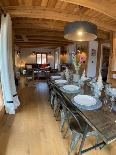 une salle à manger avec une longue table et des chaises dans l'établissement Le Gabion, luxueux appartement avec sauna, Serre chevalier Vallée, à Saint-Chaffrey