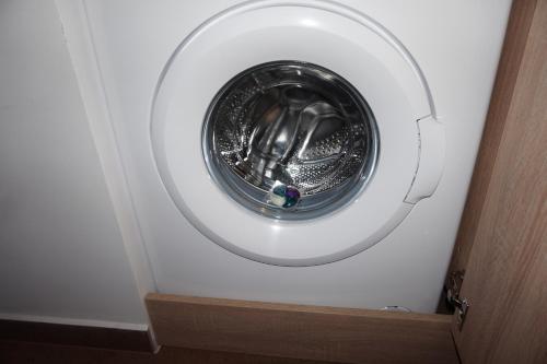 a washing machine in a room with a door at Citadella Apartament in Târgu-Mureş