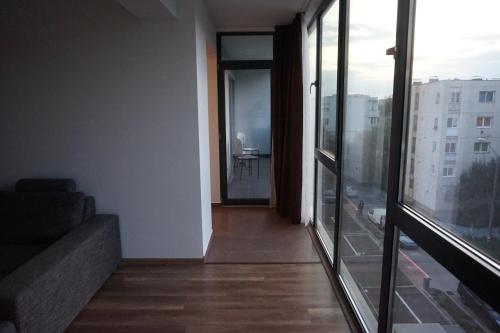 a room with a couch and a view of a balcony at Citadella Apartament in Târgu-Mureş